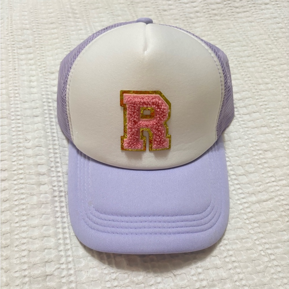 purple and white cap with pink 'R' patch